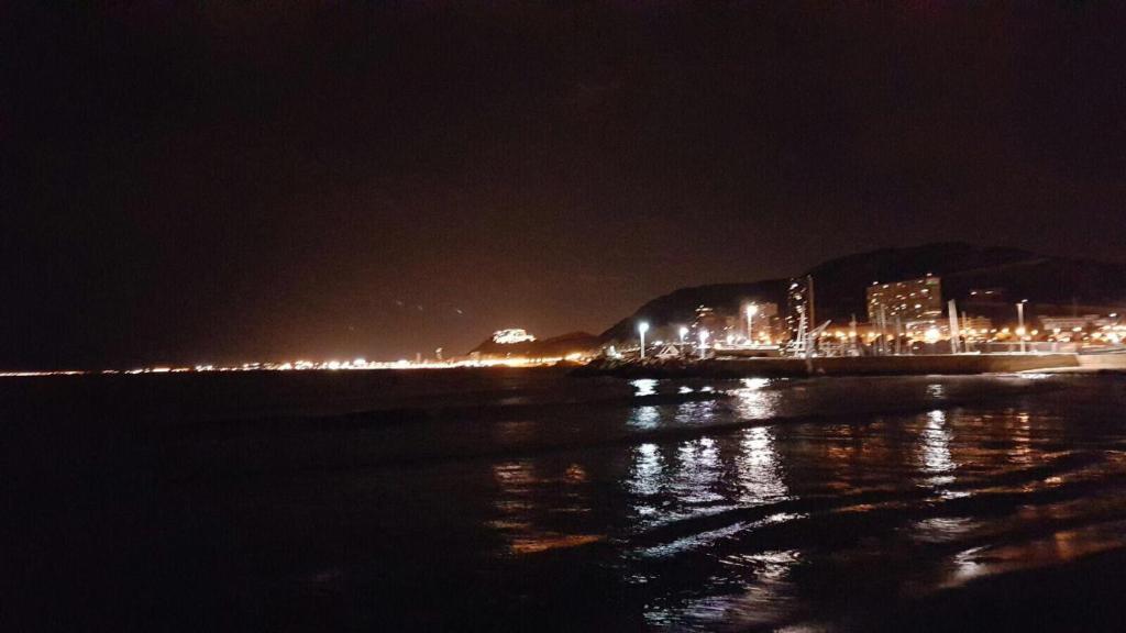 uma cidade à noite com luzes na praia em 19 Villa Playa Almadraba (Alicante) em Alicante