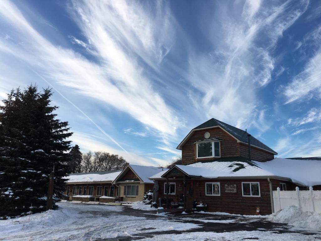 a house with snow on the roof at Big Bear Lodge in Alpena