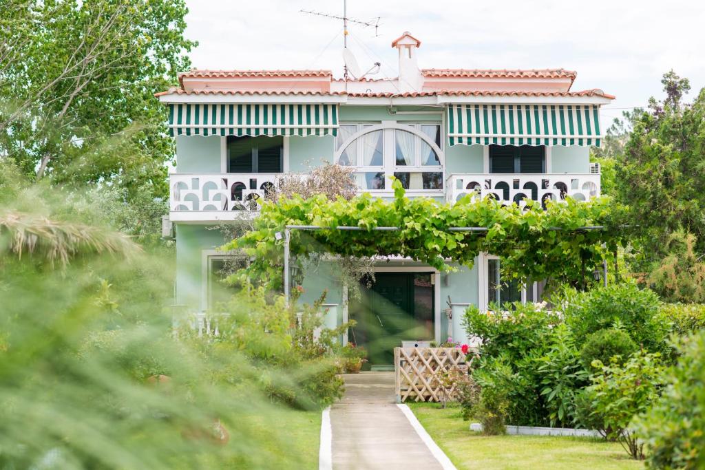 una casa bianca con un giardino di fronte di San Antonio Beach Apartments a Potos