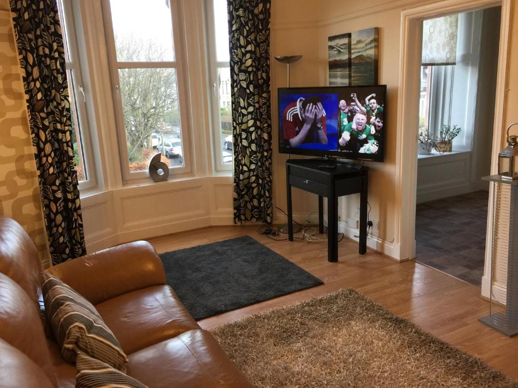 a living room with a couch and a flat screen tv at Scotstoun 1 Bed Flat in Glasgow