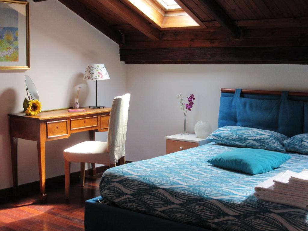 ナポリにあるIl Cielo Di Danteのベッドルーム1室(デスク、青い掛け布団付きのベッド1台付)