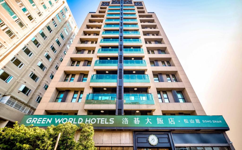 un edificio alto con un cartel delante en Green World SongShan en Taipéi