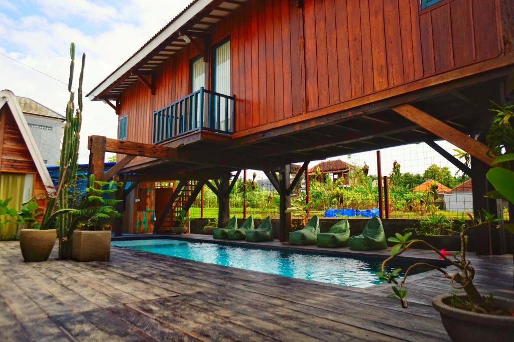 une maison avec une piscine et un balcon dans l'établissement Kampoeng Saya, à Seminyak