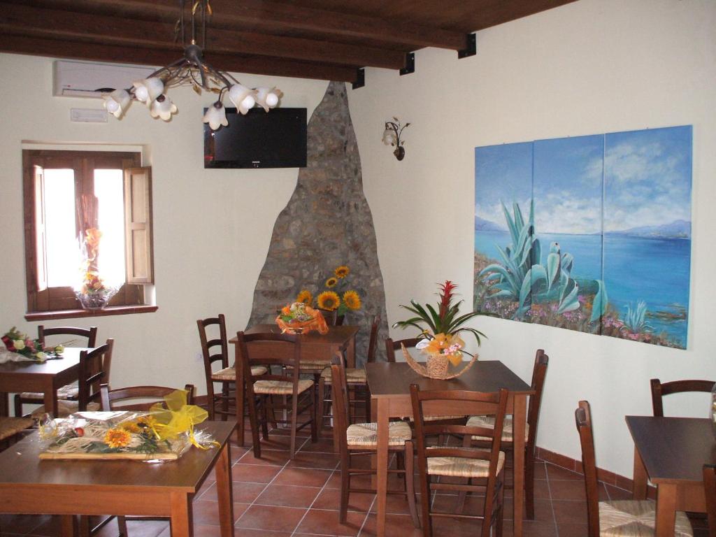 een restaurant met tafels en stoelen en een schilderij aan de muur bij Affittacamere Il Borgo in Francavilla Marittima