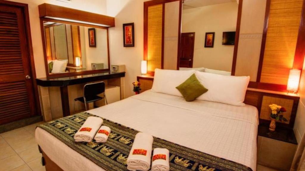 a hotel room with a bed and a desk at Bar Oz Riverside Guesthouse in Phnom Penh