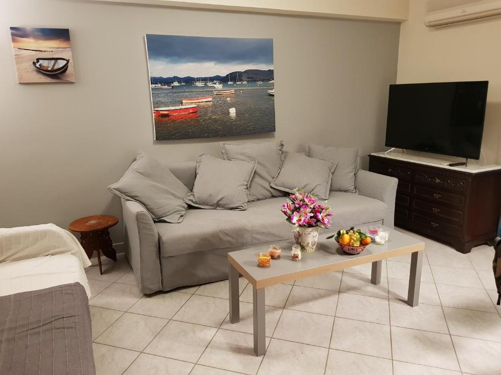 a living room with a couch and a tv at Sounio Palea Heaven in Palaiá Fókaia