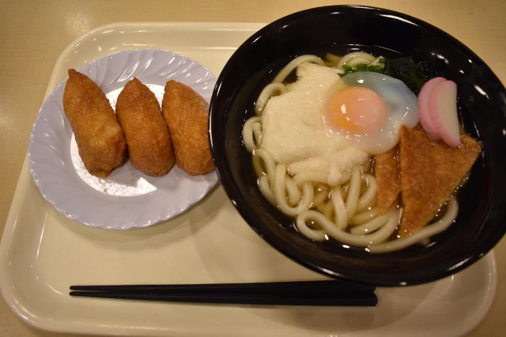 um prato de comida com uma tigela de massa e ovos em Hotel Crown Hills Toyokawa em Toyokawa