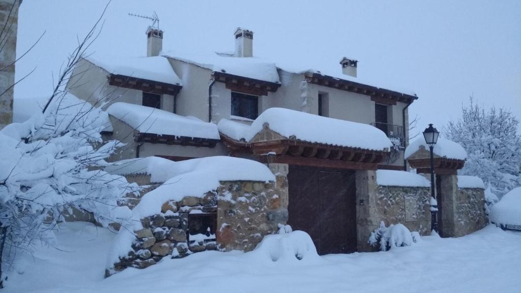una casa cubierta de nieve delante en Casas de la Fuente, en Brieva