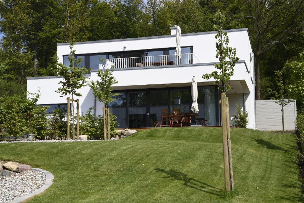 una casa blanca con césped delante en Haus Windsbraut - FeWo 01, en Ostseebad Sellin