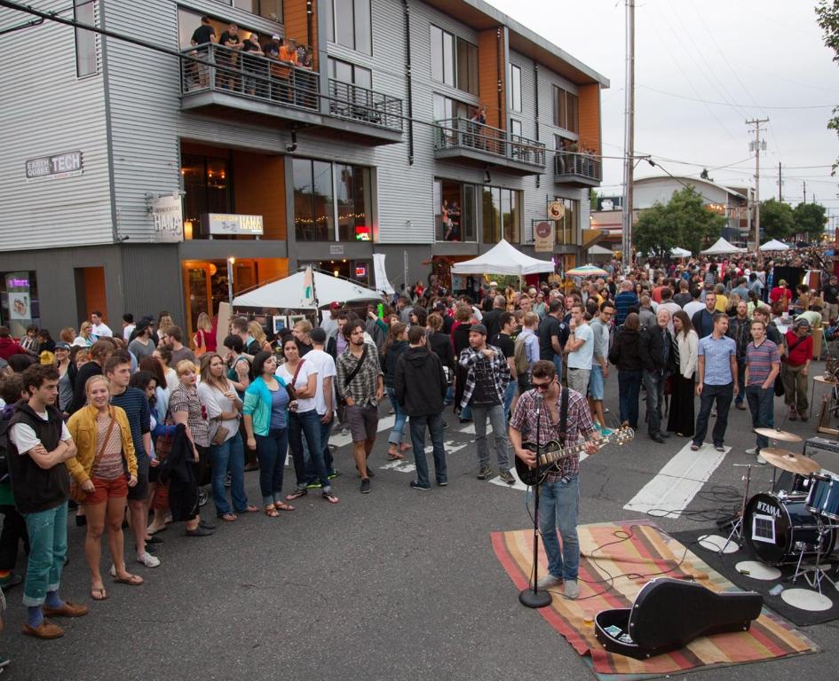 a crowd of people watching a man on a stage in the street at Duplex in Alberta Art District in Portland