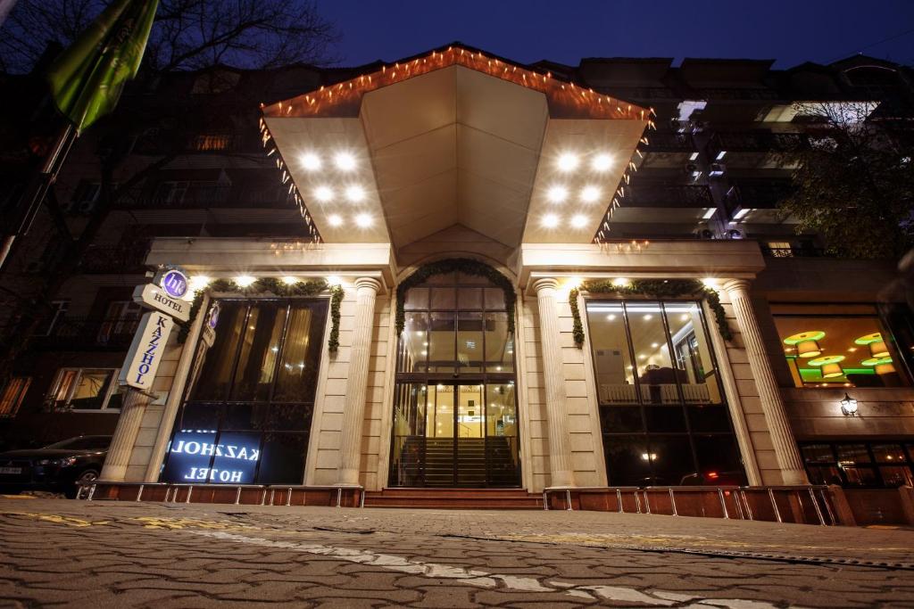 ein Gebäude mit Lichtern in der Nacht davor in der Unterkunft Hotel Kazzhol Almaty in Almaty