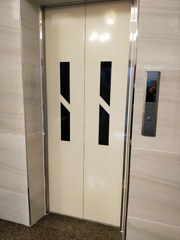 a elevator in a building with black and white doors at 墾丁秋莊會館 附限量停車位 不保證有位置 無法事先預留 背包房無車位 預訂後記得加Line聯繫 in Hengchun