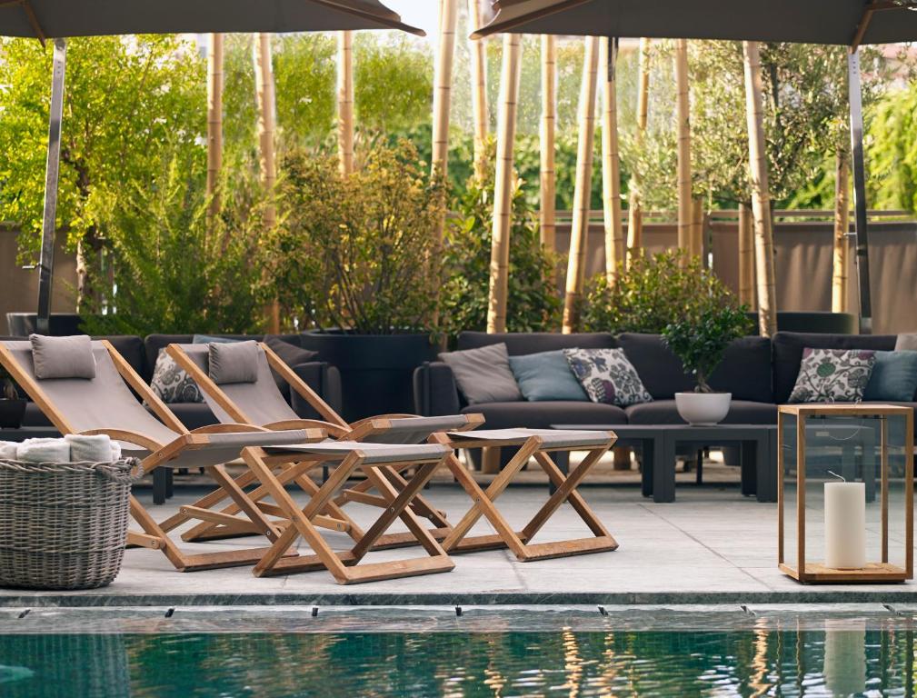 - un groupe de chaises et de tables à côté d'une piscine dans l'établissement Samaria Hotel, à La Canée