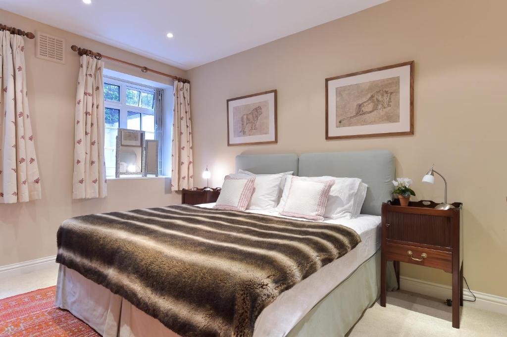 ロンドンにあるPeaceful 1 Bed Flat Off Sloane Square With Patioのベッドルーム(大型ベッド1台、窓付)