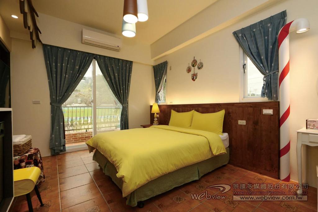 台東市的住宿－小熊管家民宿，一间卧室配有一张带黄色床单的床和一扇窗户。