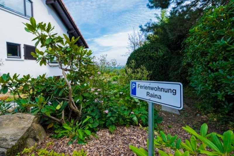 a blue and white sign in a garden at Ferienwohnung Raina in Bad Säckingen