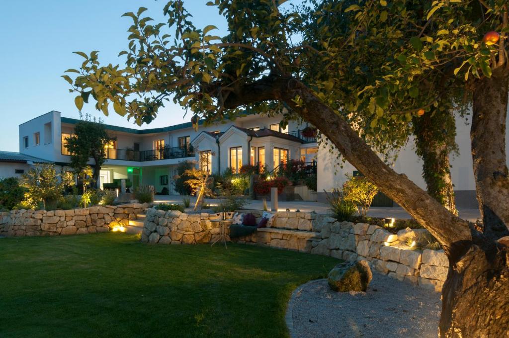 una casa con una pared de piedra frente a un patio en Haus Kranixfeld-Fischl en Mörbisch am See