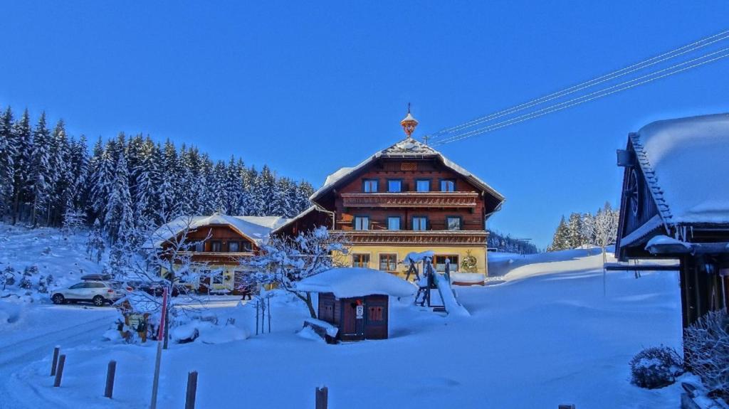 eine Ski-Lodge im Schnee davor in der Unterkunft Pension-Greimelbacherhof in Ramsau am Dachstein