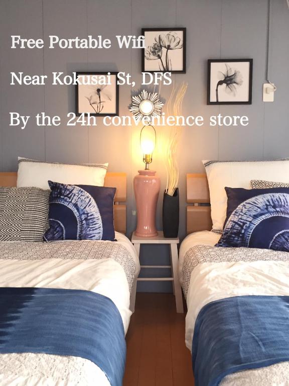 a room with two beds and a sign that reads new kokasaki stds at Holiday Homes TSUBOYA 601 in Naha
