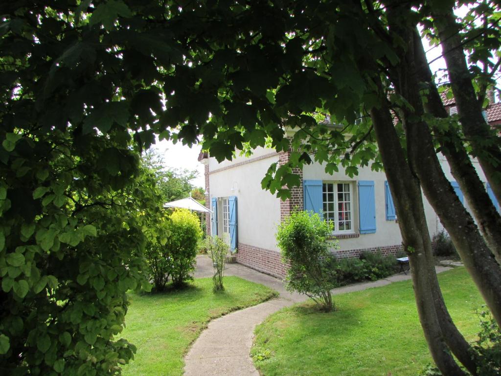 uma casa branca com persianas azuis e um caminho em Côté Prairie em Épagne-Épagnette