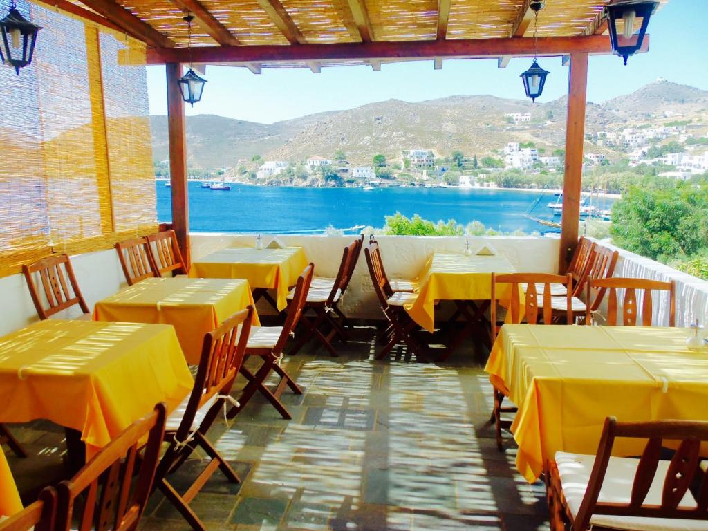 a restaurant with tables and chairs with a view of the water at Alexandros Hotel in Grikos