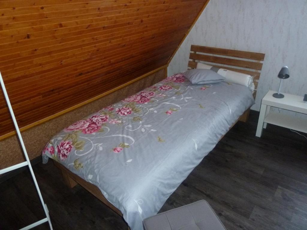 ein Bett mit einem Kopfteil aus Holz mit Blumen darauf in der Unterkunft im gelben Haus in Trusen