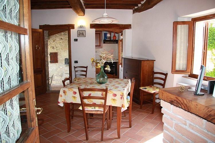 un comedor con una mesa con un jarrón de flores. en Borgo Fango, en Montieri