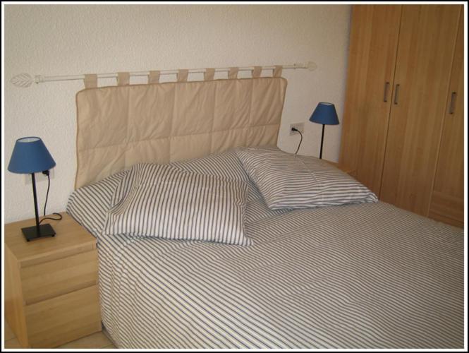 アルジェレス・シュル・メールにあるLocations Meublées Plage des Pinsのベッドルーム1室(ナイトスタンドにランプ2つ付)