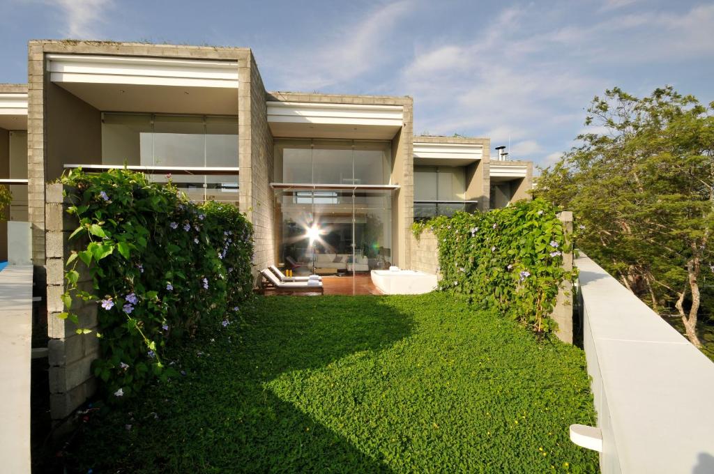 a house with a green hedge in front of it at AcquaSanta Lofts Hotel in Cali