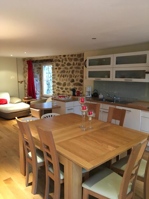 a kitchen and dining room with a wooden table and chairs at Gîte de l’Eyrieux in Les Ollières-sur-Eyrieux