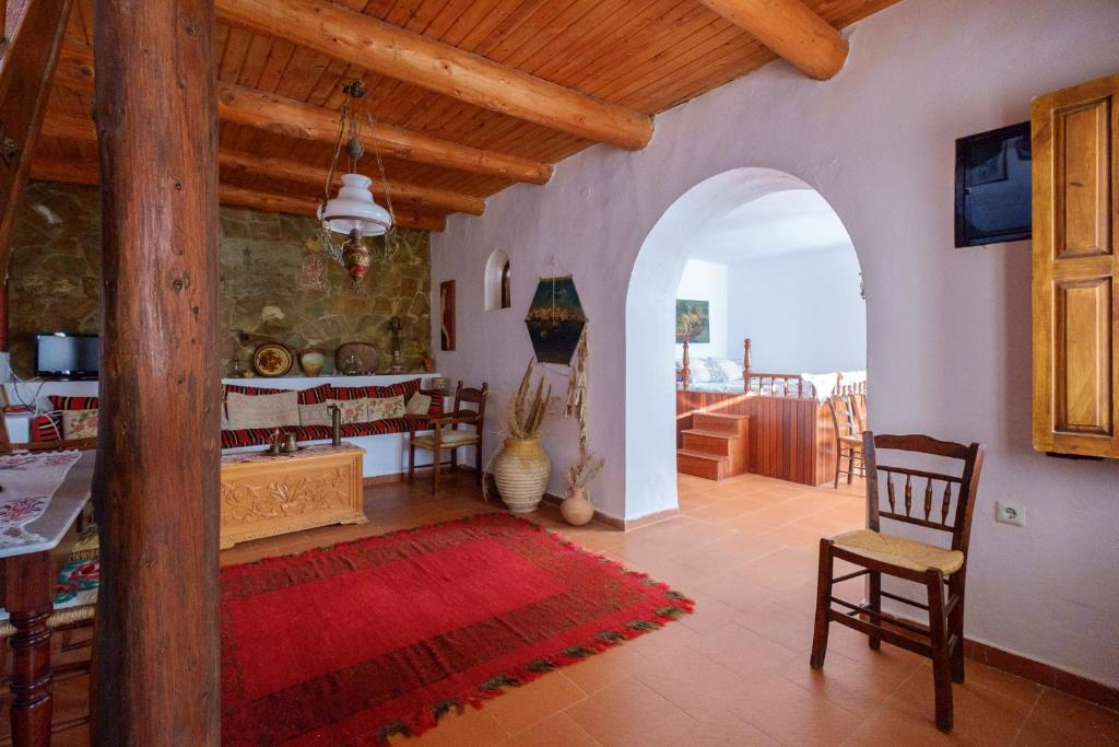 a living room with an archway and a table and chairs at Traditional Cretan Stone House 4 in Kolymvari