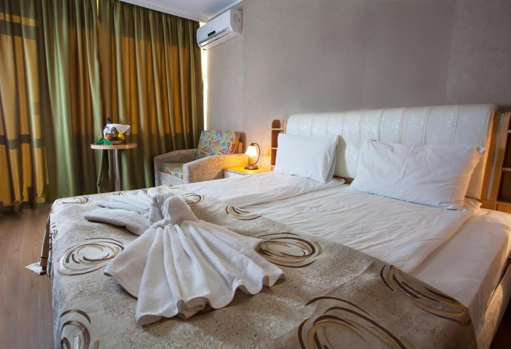 a bedroom with a bed with a dress on it at Balneo & SPA Hotel Aura in Velingrad