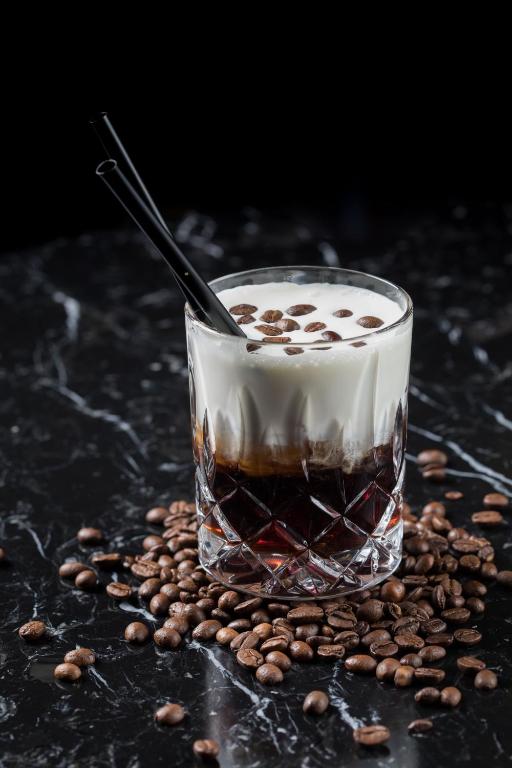 a drink in a glass sitting on a pile of coffee beans at Wyndham Stuttgart Airport Messe in Stuttgart