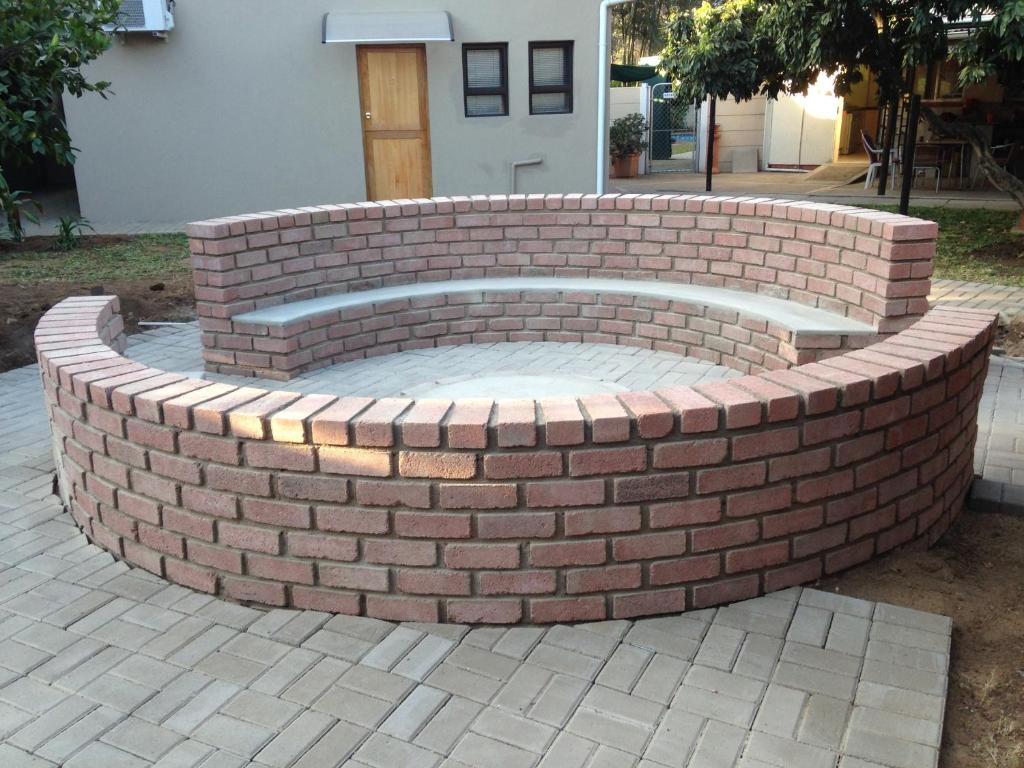 una hoguera de ladrillo construida en una pared de ladrillo en Impala Chalets, en Phalaborwa