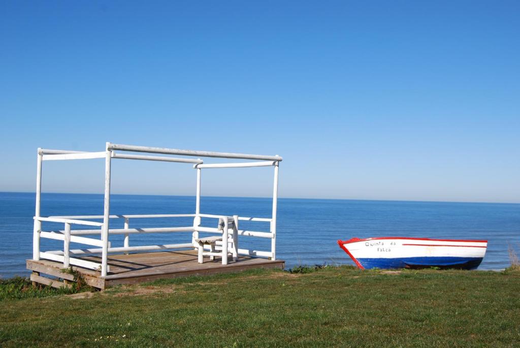 een dok met een boot naast de oceaan bij Quinta da Falca in Nazaré