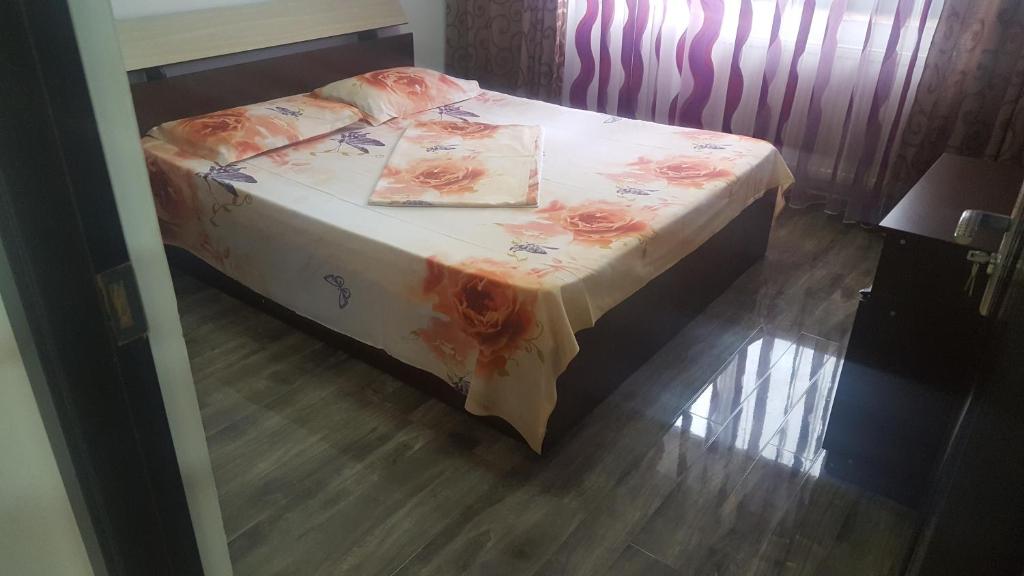 een slaapkamer met een bed met een bloemenbed en een tafel bij Apartament Luna in Mangalia