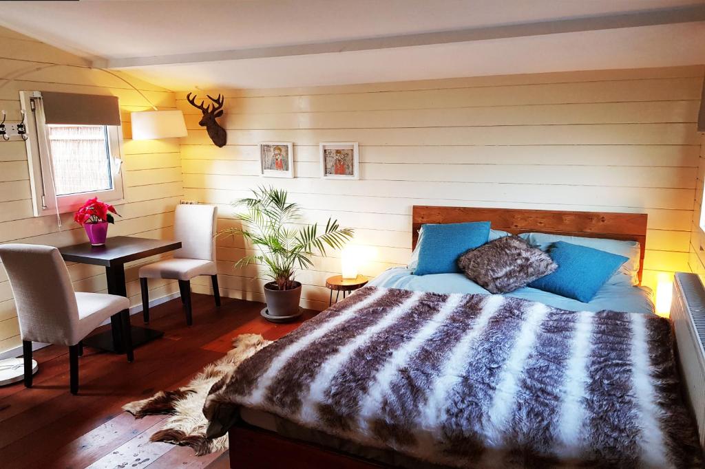 een slaapkamer met een bed, een tafel en een bureau bij Studio Lior in Amsterdam