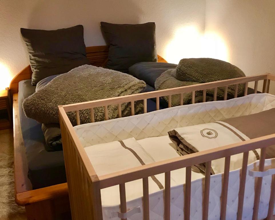 - un lit bébé dans une chambre avec un lit et un canapé dans l'établissement Schwarzwaldmädel, à St. Peter