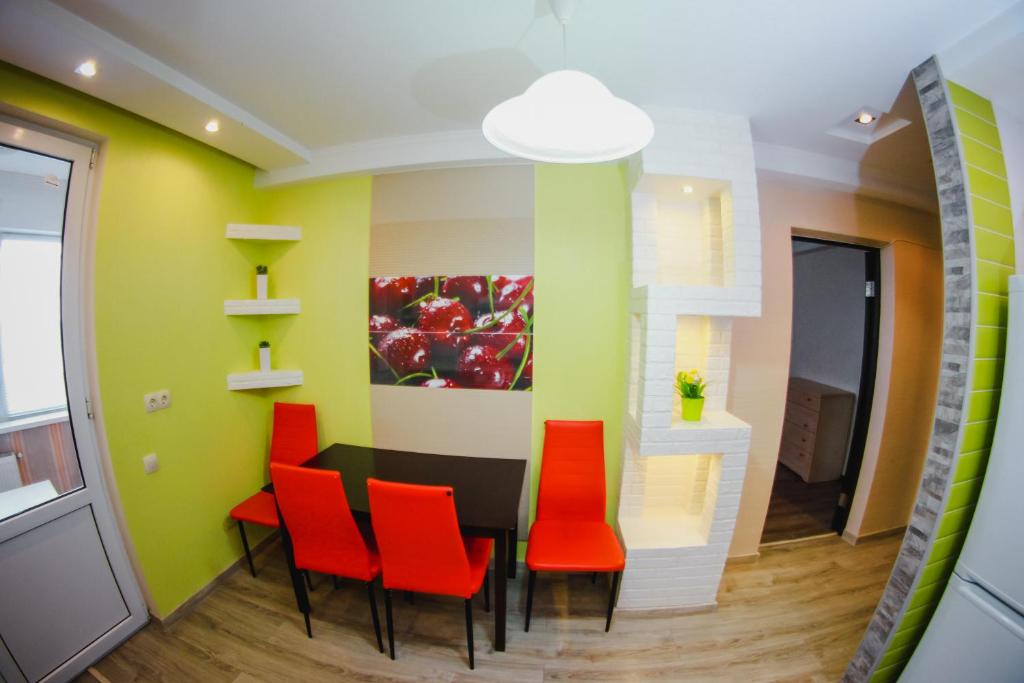un comedor con sillas rojas y una pintura en la pared en Apartment on Ion Neculce 1, ZityMall Shopping Center, Free Parking&WiFi en Chişinău