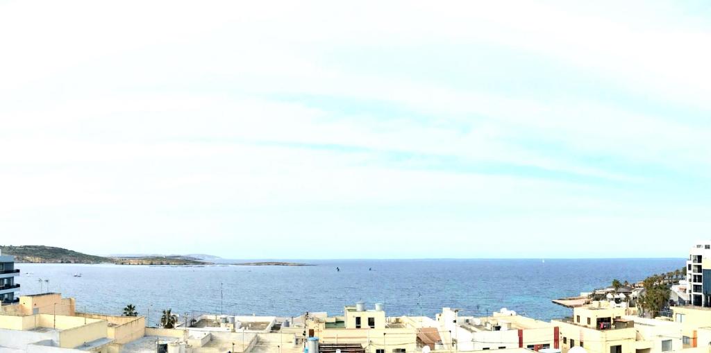 - une vue sur l'océan depuis une ville avec des bâtiments dans l'établissement Savoy, à San Pawl il-Baħar