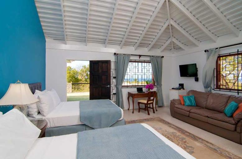 a living room with a bed and a couch at Mynt Retreat Bed & Breakfast in Montego Bay