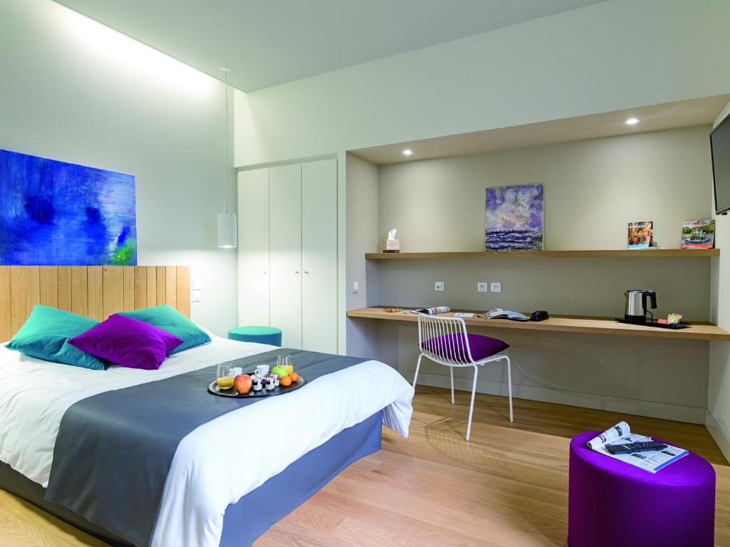 um quarto de hotel com duas camas e uma mesa com uma bandeja de frutas em Hôtel Le Domaine Du Moulin de Monjous em Gradignan