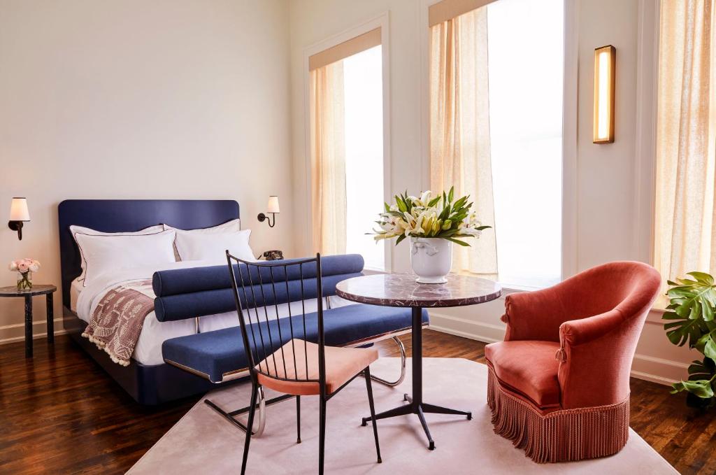 um quarto com uma cama, uma mesa e cadeiras em The Siren Hotel em Detroit