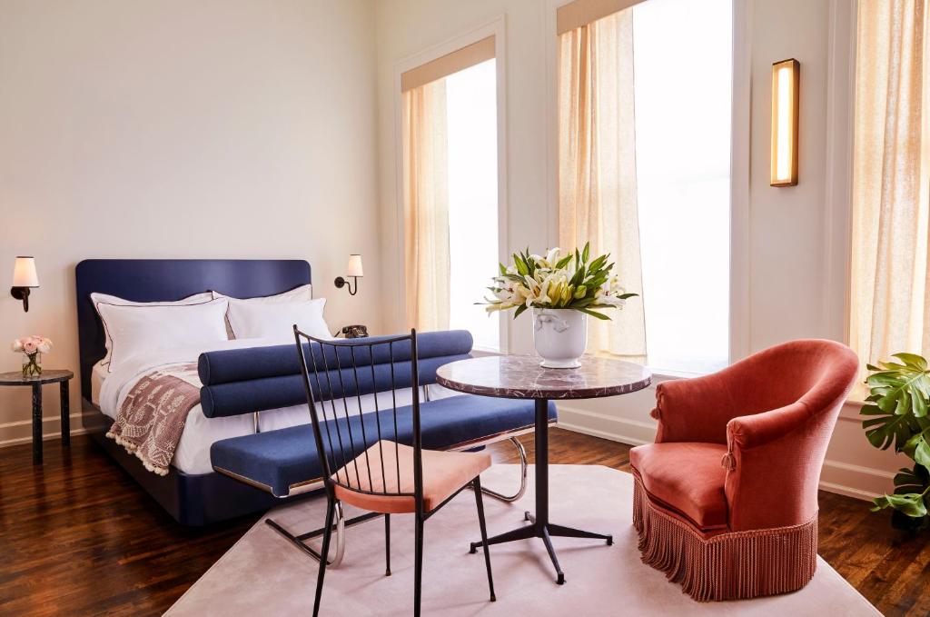 a bedroom with a bed and a table and chairs at The Siren Hotel in Detroit