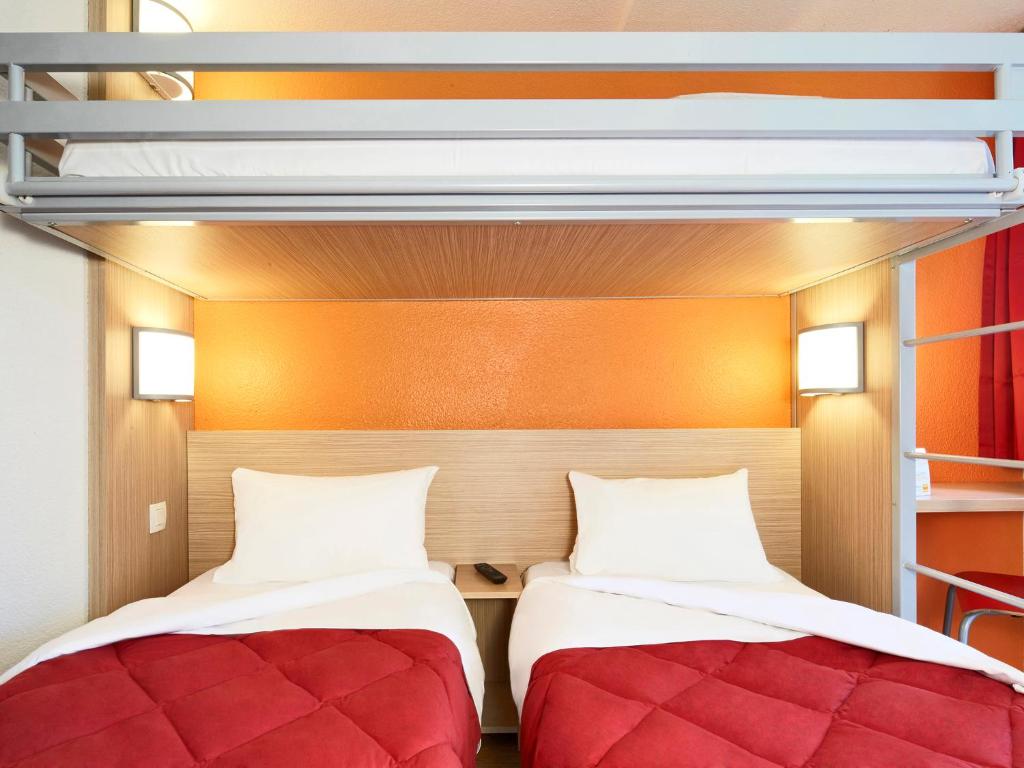 ヴィルナーヴ・ドルノンにあるプレミア クラッセ ボルドー シュド ヴィルナーヴ ドルノンの二段ベッド1組が備わるドミトリールームのベッド2台分です。
