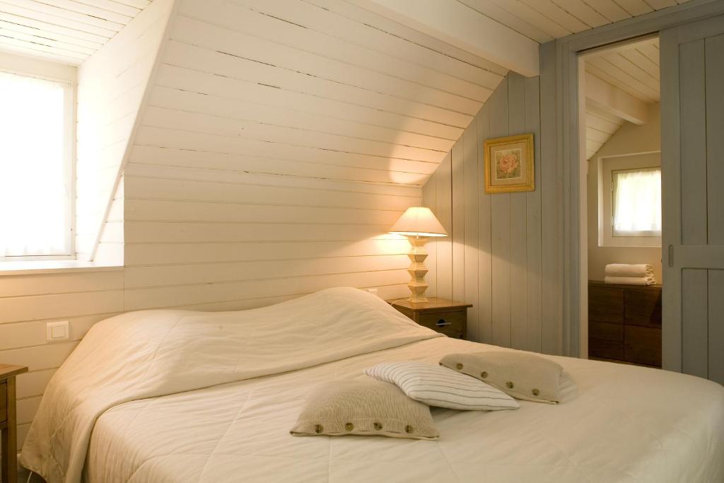 a white bed in a room with a window at Cottages De La Bretesche in Missillac