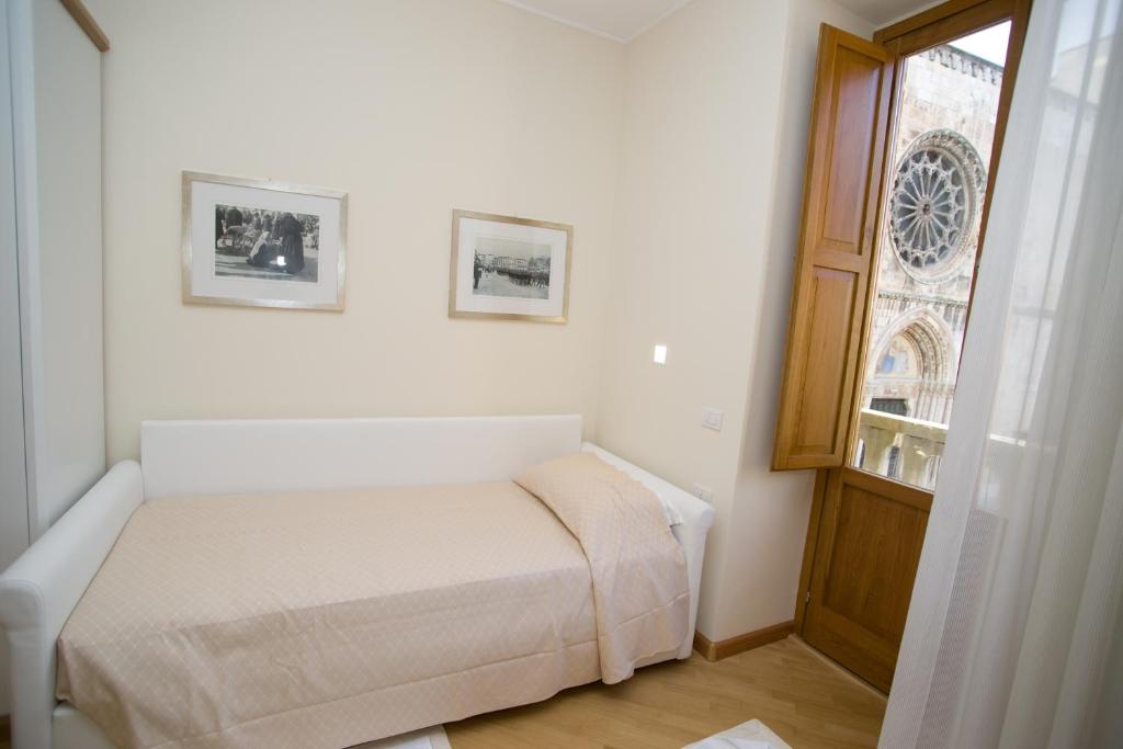 La Locanda di Gino في سولمونا: غرفة نوم صغيرة بها سرير ونافذة
