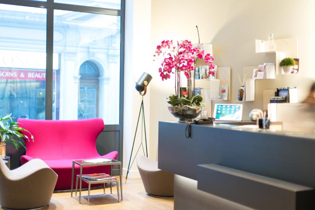 洛桑的住宿－旅客精品酒店，一个带粉红色椅子和一张书桌的办公室