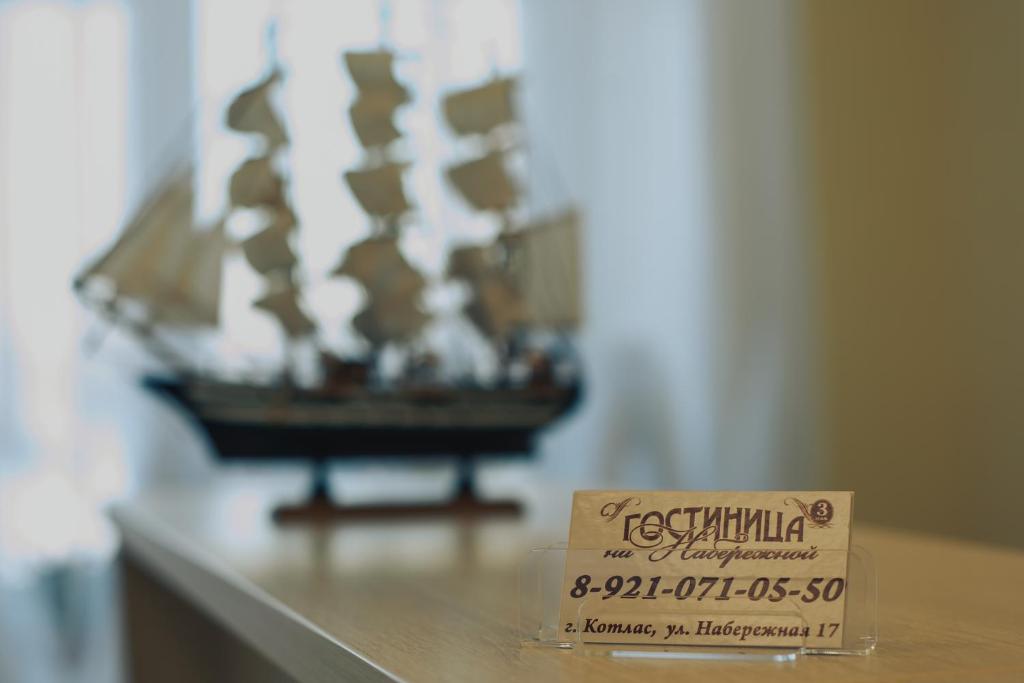 a sign sitting on top of a table with a boat at Гостиница На Набережной in Kotlas