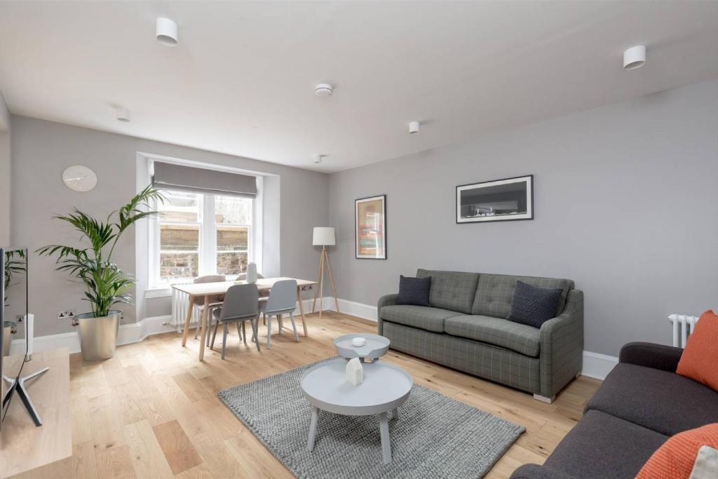 a living room with a couch and a table at ALTIDO Luxurious 2BR home near Haymarket station in Edinburgh